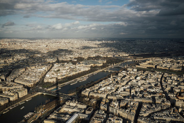 View of the city of Paris from the height of the Eiffel Tower. Beautiful Paris cityscape with Seine. Famous quay of river Seine in Paris with buildings and trees.