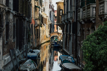 Fototapeta na wymiar Venice, Italy. Narrow Canal with old houses with parked boats. One of the most famous cities in Italy. It is located on the islands covered by canals and historic bridges. 