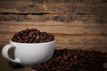 Coffee beans in a cup on a wooden table