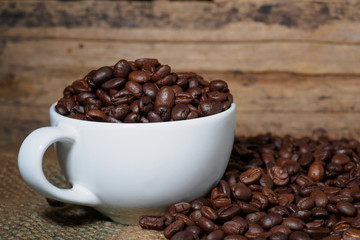 Coffee beans in a cup on a wooden table