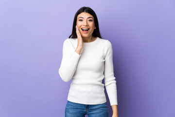 Young brunette woman over isolated purple background with surprise and shocked facial expression