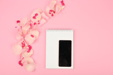 Flatlay with smartphone mock up and floral pattern at pink background. Spring shopping concept. Top view.