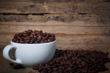 Coffee beans in a cup on a wooden table