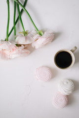Spring wallpaper. Pink  flowers and marshmallows on a white background. Flowers composition. Flat lay, top view, copy space. 