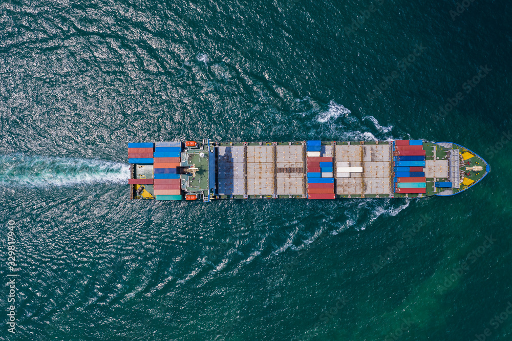 Wall mural cargo ship sailing on the sea top view from drone