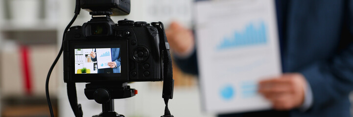 Male in suit and tie show stats graph pad making promo videoblog or photo session in office camcorder to tripod closeup. Vlogger selfie sale solution or finance advisor management information © H_Ko