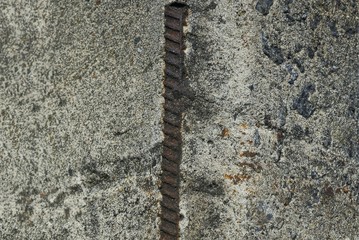 a piece of gray broken concrete wall with brown rusty iron reinforcement