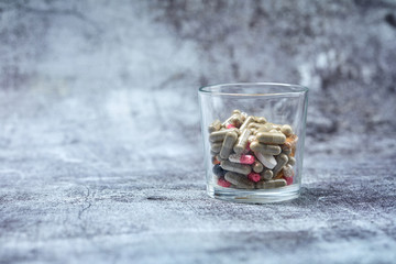 medicine pills and capsules on grey surface