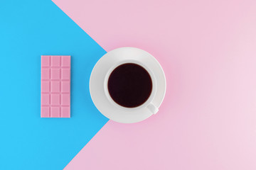 A cup of freshly brewed coffee on beautiful pink and bright blue pastel background.