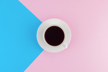 A cup of freshly brewed coffee on beautiful pink and bright blue pastel background.