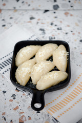 Raw fresh dumplings with meat or vegetarian dumplings with soy and spinach on black background. Food and cooking in the kitchen concept. Place for text. Copy space