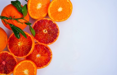 Platter of orange and mandarosa red clementines cut in half on a white platter