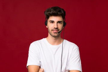Young man over isolated background working with headset