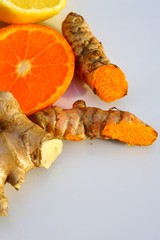 Plate of fresh ingredients for immunity booster drink with turmeric, ginger, orange and lemon
