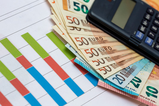 Business crisis and economic crisis concept image. Pile of Euro banknotes with calculator on analysis and data sheets. - Powered by Adobe