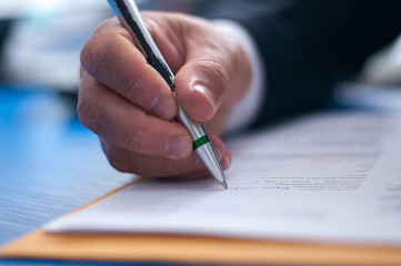 Closeup businessman signing paperwork