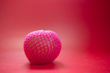 Red apples wrapped by pink foam net protection