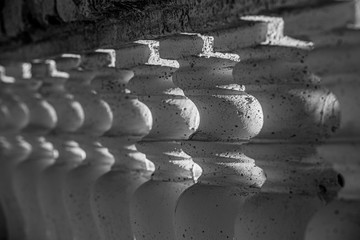 Abstract row of white columns made of stone close-up, black and white image