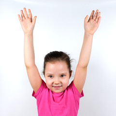 Caucasian little smiling girl raising her hands up on white background. Sport, physical training, physical jerks, healthy lifestyle, health, physical exercise concept.