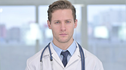 Portrait of Young Male Doctor Looking at Camera in Office