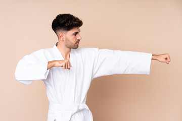 Young man over isolated background doing karate
