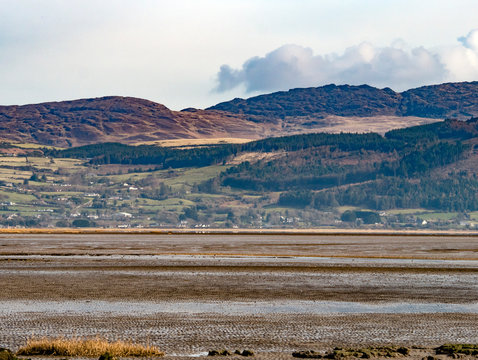 Rugged Irish landscape with hills and coastline at low tide 