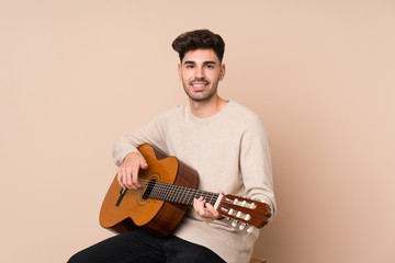 Young man with guitar over isolated background