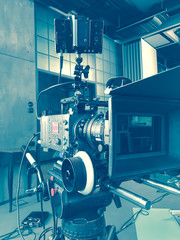 movie camera on the tripod, interior set