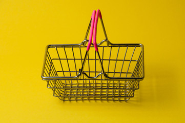 Shopping basket on a yellow background. Supermarket food price concept.