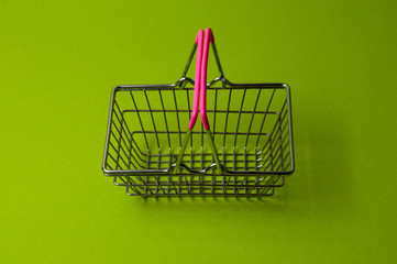 Shopping basket on a green background. Supermarket food price concept, holiday discounts