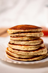 Stack of breakfast american pancakes on white background. Close up. Vertical orientation