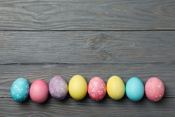 Multicolor Easter eggs on wooden grey background, space for text