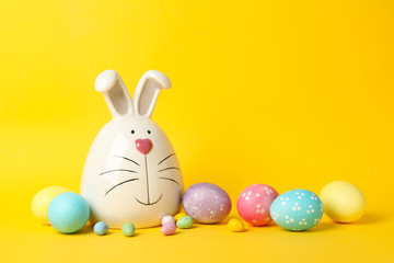 Bunny and Easter eggs on yellow background, space for text