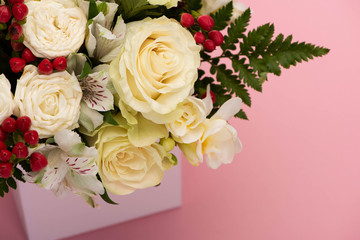 close up view of bouquet of flowers in festive gift box on pink background