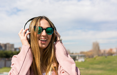 Young and happy girl is dancing while listening to music