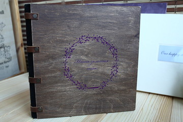 album photo book with  the inscription in a brown wooden cover with with a decor next to flowers