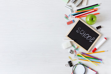 School supplies on white wooden table top view.