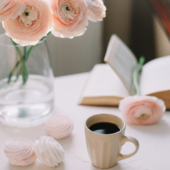 Spring home interior decor. Coffee cup, flowers, book. Decorated interior in living room. Blog, website or social media concept 