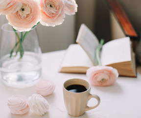 Spring home interior decor. Coffee cup, flowers, book. Decorated interior in living room. Blog, website or social media concept 