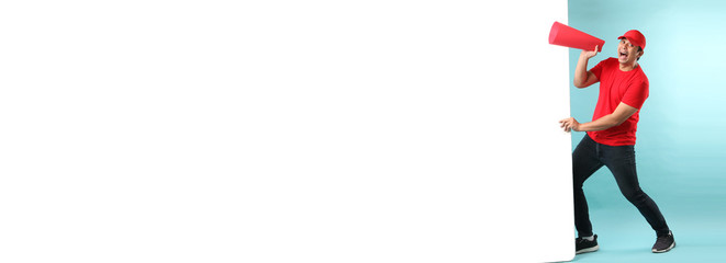 handsome of Asian man are using megaphone to speak and pulling big white board, on blue background in studio With copy space.