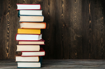 A stack of old books on a wooden background copy space.