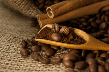Coffee on wooden spoon on a burlap textured background