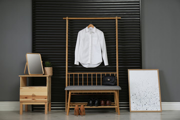 Hallway interior with modern furniture, mirror and hanging shirt