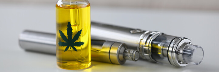 Organic extra virgin cannabinoid oil with vipe pen system against home background. Medical...