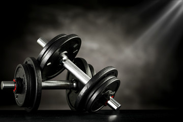 Obraz na płótnie Canvas Dark interior of gym and dumbbells.Free space for your decoration and healthy life 