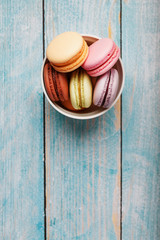 Macaroni cookies are placed in a white plate on a blue wooden background.