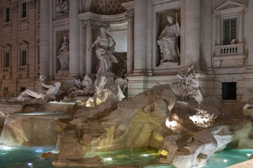 Night photo of the illuminated Trevi Fountain, Rome, Italy. The most famous late Baroque Roman fountain. White marble sculptures in the water.