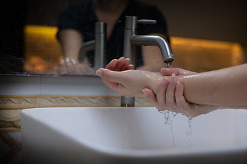 The beautiful female hand that applying soap in the sink from or anti-bacteria to prevent the...