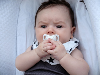 Bebé pequeño tumbado en camita de bebé