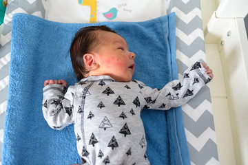 Bebé pequeño tumbado en camita de bebé